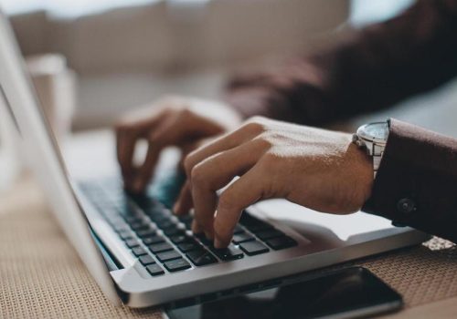 Hands typing on laptop computer