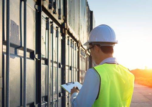 Foreman control loading Containers box from Cargo freight ship